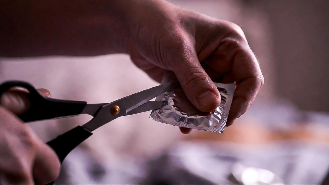 Відкриття презервативу за допомогою ножиць